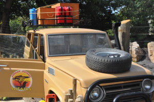 photo - safari truck,brown, with luggage in the luggage rack, xtra tire on hood of truck, used for display at african outpost, advertising safaris