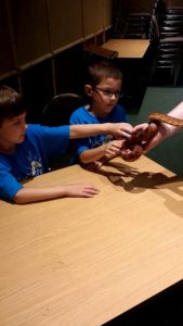 photo - kids holding corn snake, with keeper assistance, during Safari day camp