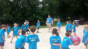 photo - group of Safari day campers, boys and girls, playing group game of dodge ball on a sunny summer day