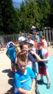 photo - Safari day campers, waiting in line, to get into the zoo splash park on a sunny summer day