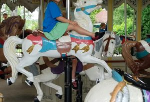 photo - day camper riding horse at the carousel