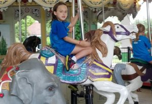 photo - young girl, riding horse, on the zoo carousel