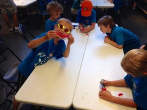 photo - group of Safari day campers, playing with hide and seek, play doh, on a table in a classroom
