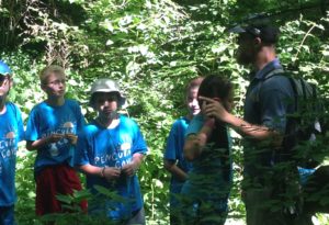 photo - group of day campers, with a counselor, giving talk about wild survival in the wetlands