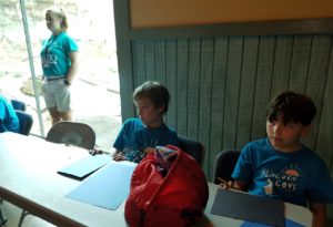 photo - couple of zoo camper boys, paying attention to directions, zoo counselor standing in background
