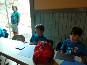 photo - couple of zoo camper boys, paying attention to directions, zoo counselor standing in background