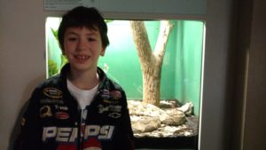 shelby elementary boy stand in front of snake tank