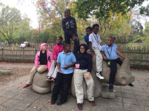 roosevelt perry students sit on top of rhino statue