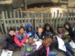 cochran students sit in front of lion exhibit