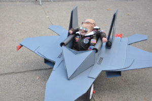 photo - 2 small boys in costumes as fighter pilots, sitting in jet fighter plane, as seen in movie top gun