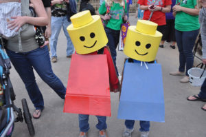 image - two kids dressed as colored plastic buildig blocks, yellow heads, blue or red bodies