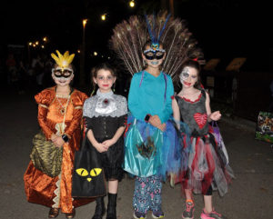 photo - 4 girls in halloween costumes, a peacock, blue outfit; princess, orange outfit; zombie in black, scarf skirt red, black, purple; girl dressed in dark dress with neck jewel scarf