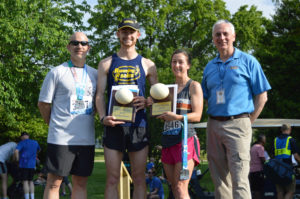 photo - John Walczak, a runner with medal from race, and male/female winners of the 5K race, holding their first place plaques, with big egg displayed on it, also have their medals for the 5K race.