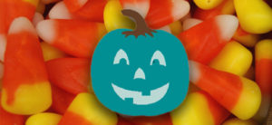 image - candy corn morsels, with blue pumpkin laying on top of the pile of candy