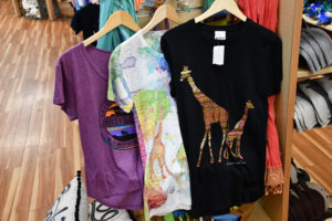 photo - variety of ladies t shirts for purchase from gift shop - ts with multi designed giraffes, pastel designed colors w/giraffes, emblem of Louisville Zoo t shirts