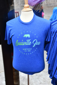 photo - short sleeve blue zoo t-shirt with Education , Conservation, Louisville Zoo, kentucky est. 1969 w/rhino white shadow image, that visitors could purchase at gift shop