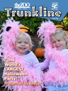 image - celebrating 50 years, theZOO, 1969- 2019, Trunkline, Fall 2019, with 2 little girls, dressed in flamingo pink feather baos, "The World's Largest Halloween Party!" Presented by Meijer, background has pumpkin and green bushes