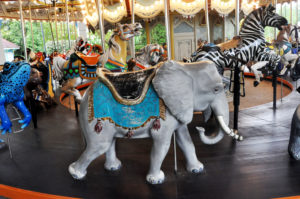 photo - carousel animal ride grey elephant with decorative tasseled blue blanket, and black saddle