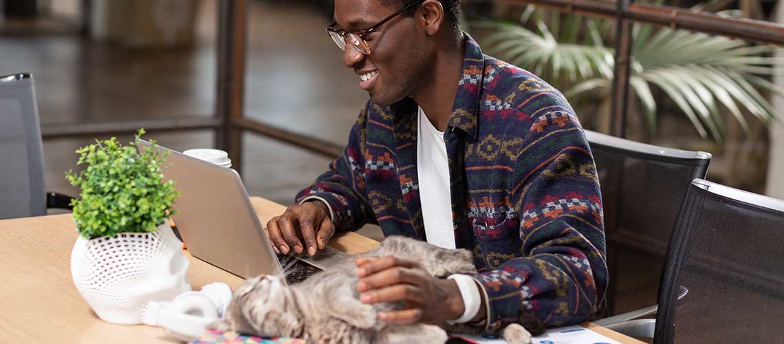 Man on computer with cat