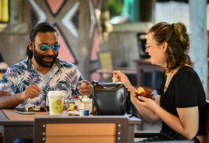 photo of two zoo visitors , eating lunch at outpost (?)