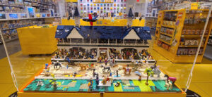 photo of large Lego setup of Churchill Downs Twin Spires and stands with spectators, field of horses with jockeys and backside stables with horses and grooms