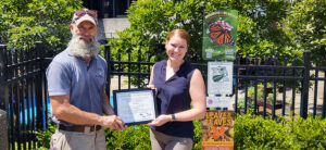 Matt Lahm, education department, offering certificate to members of the Monarch's and Milkweed pollinator project.
